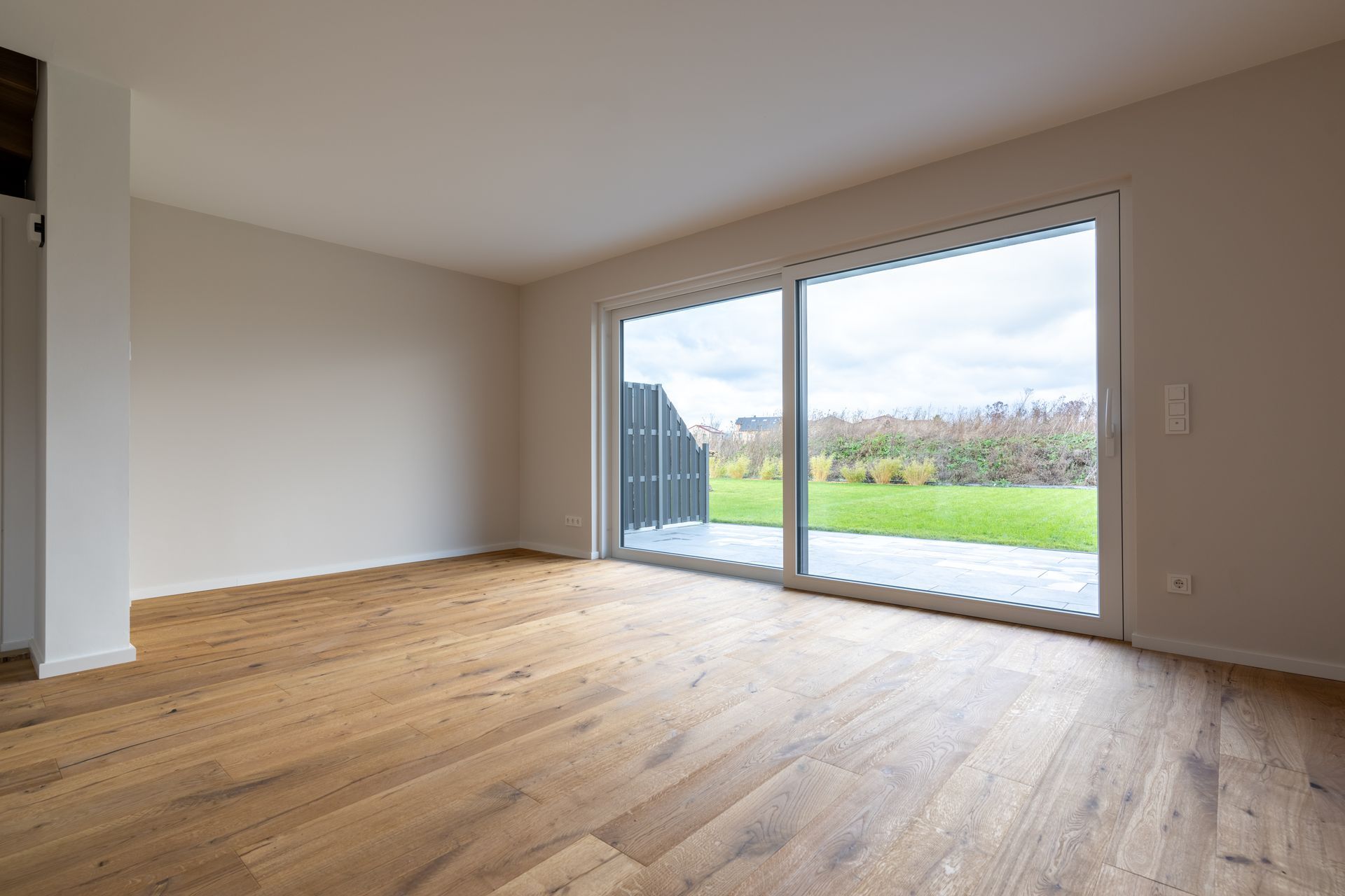 Wohnraum mit bodentiefer Fensterfront und Eichenparkett
