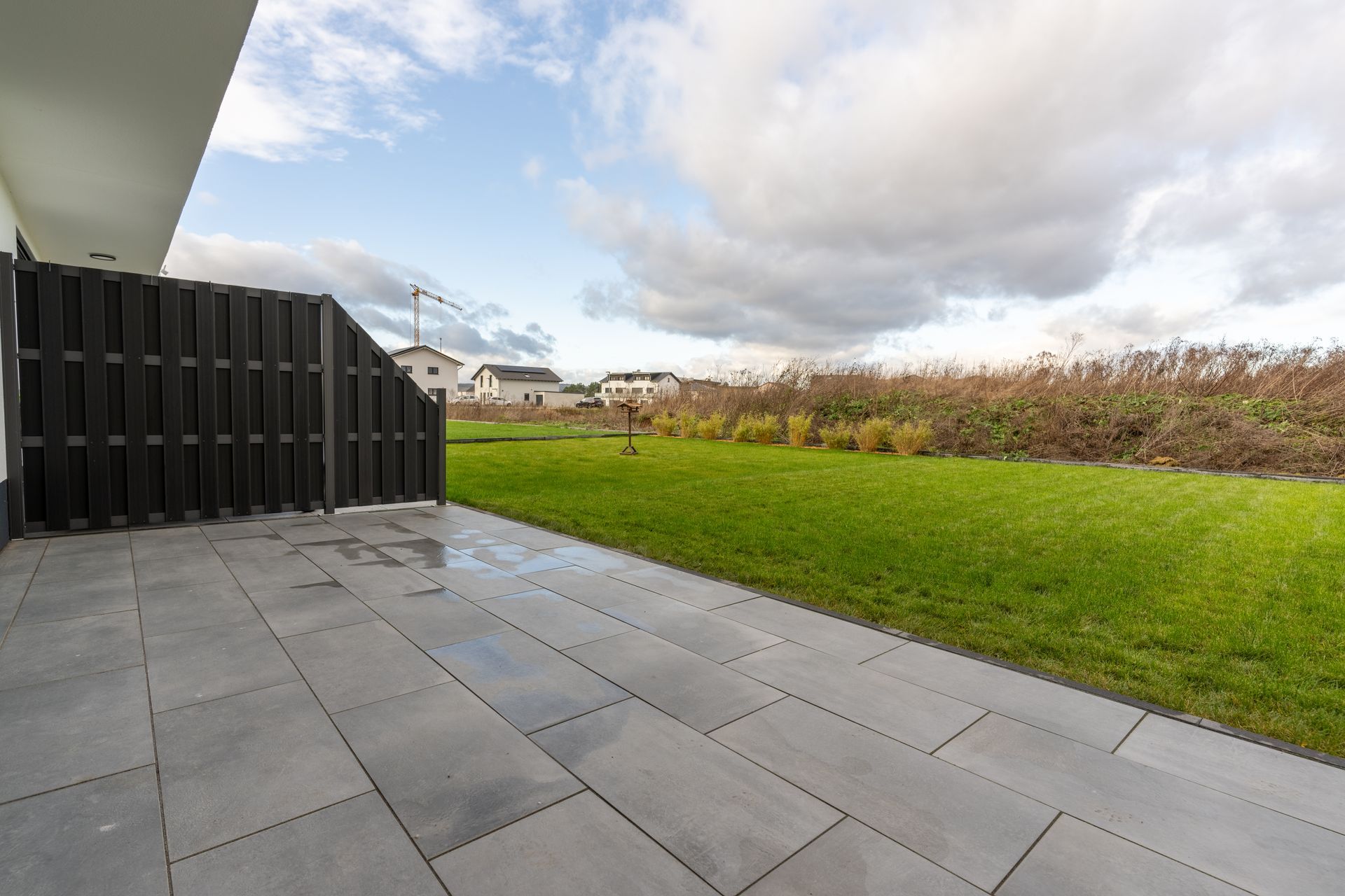 Gepflasterte Terrasse mit angrenzendem Garten
